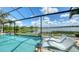 Inviting screened-in pool area with comfortable lounge chairs overlooking a serene lake at 7665 Haddington Cv, Bradenton, FL 34202