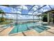 Gorgeous screened-in pool and hot tub with travertine deck overlooking the lake at 7665 Haddington Cv, Bradenton, FL 34202