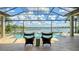 Outdoor pool features a beautiful view of the lake and comfortable seating area at 7665 Haddington Cv, Bradenton, FL 34202