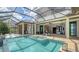 Screened pool area featuring a spa and outdoor kitchen with lake views, perfect for upscale outdoor living and relaxation at 7665 Haddington Cv, Bradenton, FL 34202