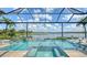 Inviting screened-in pool and hot tub area with a view of the lake and fountain at 7665 Haddington Cv, Bradenton, FL 34202