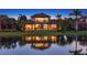 Stunning lakefront home with expansive windows, offering beautiful views and outdoor living spaces for relaxation and entertaining at 7665 Haddington Cv, Lakewood Ranch, FL 34202