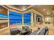 Beautiful screened outdoor living space featuring a fireplace, comfortable seating, and a pool with a tranquil lake view at 7665 Haddington Cv, Lakewood Ranch, FL 34202