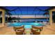 Inviting screened-in pool and spa area with lake view, fire bowls, and comfortable seating for outdoor relaxation and entertaining at 7665 Haddington Cv, Lakewood Ranch, FL 34202