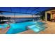 Stunning pool and spa area with a screened enclosure, offering a serene lake view and outdoor dining and lounge space at 7665 Haddington Cv, Lakewood Ranch, FL 34202