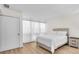 Bright bedroom with wood floors, large windows, and a comfortable queen size bed at 800 S Blvd Of The Presidents # 16, Sarasota, FL 34236