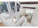 Open-concept living room with soaring ceilings and staircase with big windows at 800 S Blvd Of The Presidents # 16, Sarasota, FL 34236