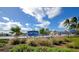 Community pool with a 'Lido Pool' sign surrounded by tropical vegetation under a bright blue sky at 800 S Blvd Of The Presidents # 16, Sarasota, FL 34236