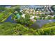Stunning aerial view of a waterfront community featuring tennis courts and tropical landscaping at 8183 Nice Way, Sarasota, FL 34238