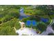Aerial shot of community amenities with tennis courts, pool, basketball court, beautiful landscaping, and winding waterways at 8183 Nice Way, Sarasota, FL 34238