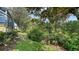 Lush backyard featuring mature trees and landscaping, creating a private outdoor space at 8183 Nice Way, Sarasota, FL 34238