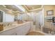 Bathroom with a double vanity, framed mirror, walk-in shower, and a linen closet at 8183 Nice Way, Sarasota, FL 34238