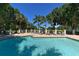 Community pool featuring lounge chairs and mature landscaping at 8183 Nice Way, Sarasota, FL 34238