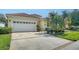 Inviting home with an attached garage, well-manicured lawn, and mature landscaping at 8183 Nice Way, Sarasota, FL 34238