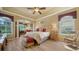 Spacious main bedroom with tray ceilings, wood floors, sitting area, and large windows offering natural light at 8183 Nice Way, Sarasota, FL 34238