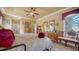 Bright main bedroom features decorative dresser, wood floors, tray ceilings, and large windows offering natural light at 8183 Nice Way, Sarasota, FL 34238