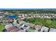 An aerial view showcases this home's neighborhood location near a pond and adjacent to a lush greenbelt at 8668 Sundance Loop, Sarasota, FL 34238