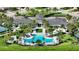 Aerial view of a community clubhouse, pool, and tennis courts, surrounded by lush landscaping at 8668 Sundance Loop, Sarasota, FL 34238