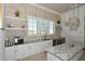 Modern kitchenette features sleek white cabinetry, granite countertops, and stainless steel appliances, perfect for entertaining at 8668 Sundance Loop, Sarasota, FL 34238