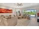 Inviting living room with a comfortable sectional sofa, plush rug, and sliding glass doors to the lanai at 8668 Sundance Loop, Sarasota, FL 34238