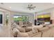 Spacious living room featuring a large sectional sofa, neutral decor, and a large television screen at 8668 Sundance Loop, Sarasota, FL 34238