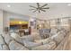 Spacious living room featuring an oversized gray sectional sofa, large screen tv and adjacent kitchen area at 8668 Sundance Loop, Sarasota, FL 34238