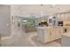 Open-concept living space with light floors, a gourmet kitchen, and sliding glass doors with natural light at 8668 Sundance Loop, Sarasota, FL 34238