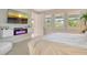 Bright bedroom with an electric fireplace, plantation shutters, and a view to the en suite at 8668 Sundance Loop, Sarasota, FL 34238