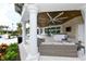 Inviting outdoor lounge with comfortable seating, ceiling fans, and a TV for relaxing and socializing by the pool at 8668 Sundance Loop, Sarasota, FL 34238