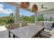 Enjoy alfresco dining on the patio, complete with a dining table, ceiling fans, and a view of the lush backyard at 8668 Sundance Loop, Sarasota, FL 34238