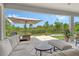A beautifully arranged patio features comfortable seating, a fire pit, and a serene view of the backyard at 8668 Sundance Loop, Sarasota, FL 34238