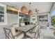 Covered patio with a dining area, wicker furniture, ceiling fans, and a mounted TV at 8668 Sundance Loop, Sarasota, FL 34238