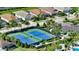 Aerial view of community tennis courts with lush landscaping and homes in the background at 8668 Sundance Loop, Sarasota, FL 34238
