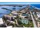 Aerial view showcasing condos, tennis courts, lush landscaping and water views at 8735 Midnight Pass Rd # 602B, Sarasota, FL 34242