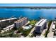 Stunning aerial shot of waterfront condominiums with a serene pool and lush green surroundings at 8735 Midnight Pass Rd # 602B, Sarasota, FL 34242