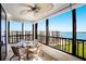 Inviting balcony features comfortable seating, a glass table, and scenic views of the bay and surrounding area at 8735 Midnight Pass Rd # 602B, Sarasota, FL 34242