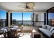 Relaxing balcony with wicker seating, glass table, ceiling fan, and stunning water views at 8735 Midnight Pass Rd # 602B, Sarasota, FL 34242