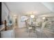 Open dining area with chandelier, glass table, and adjacent living area with view into the kitchen at 8735 Midnight Pass Rd # 602B, Sarasota, FL 34242