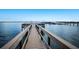 Beautiful waterfront view of a long wooden dock leading to boat slips in a serene and scenic community at 8735 Midnight Pass Rd # 602B, Sarasota, FL 34242