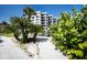 Condo building amidst tropical landscaping, providing a serene and picturesque setting at 8735 Midnight Pass Rd # 602B, Sarasota, FL 34242