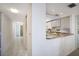 Hallway leading to the kitchen features tile flooring and views of the well-lit kitchen and dining area at 8735 Midnight Pass Rd # 602B, Sarasota, FL 34242