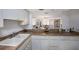 Bright kitchen featuring white cabinetry, tile flooring, and butcher block countertops with views to the living area at 8735 Midnight Pass Rd # 602B, Sarasota, FL 34242