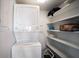Convenient laundry area with a stacked washer and dryer, plus shelving for efficient storage at 8735 Midnight Pass Rd # 602B, Sarasota, FL 34242