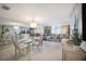 Bright living and dining area features mirrored wall, glass table, plush sofa, and access to the balcony at 8735 Midnight Pass Rd # 602B, Sarasota, FL 34242