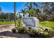 Turtle Bay sign with colorful flowers and landscaping near the tennis court and condos at 8735 Midnight Pass Rd # 602B, Sarasota, FL 34242