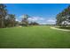 Expansive backyard featuring lush green grass, mature trees, and a quaint wooden structure for relaxing at 8985 Royal River Cir, Parrish, FL 34219