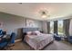 A beautifully decorated bedroom features plush bedding, gray walls, and ample natural light from the windows at 8985 Royal River Cir, Parrish, FL 34219