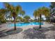A beautiful community pool area featuring palm trees, lounge chairs, and clear blue water under a bright blue sky at 8985 Royal River Cir, Parrish, FL 34219