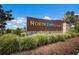 Entrance sign for North River Ranch featuring stone base, landscape, and blue sky at 8985 Royal River Cir, Parrish, FL 34219