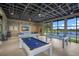 Community game room with multiple billiards tables and a relaxing seating area with beautiful lake views at 8985 Royal River Cir, Parrish, FL 34219